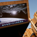A giant screen shows a view of earth from the Tianhe core module of China's space station, at a shopping mall in Beijing